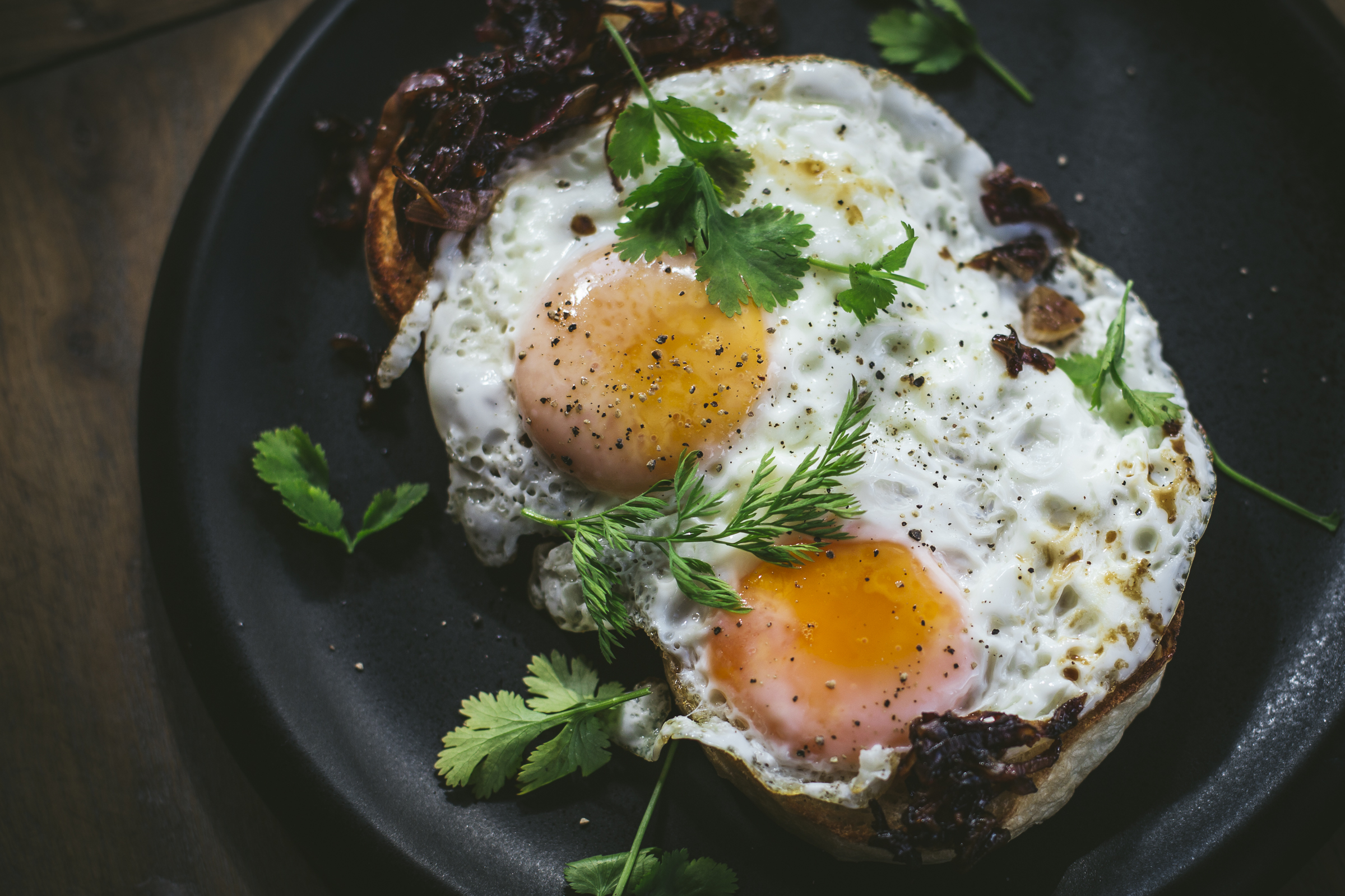 Fried eggs with garden herbs and caramelised onions