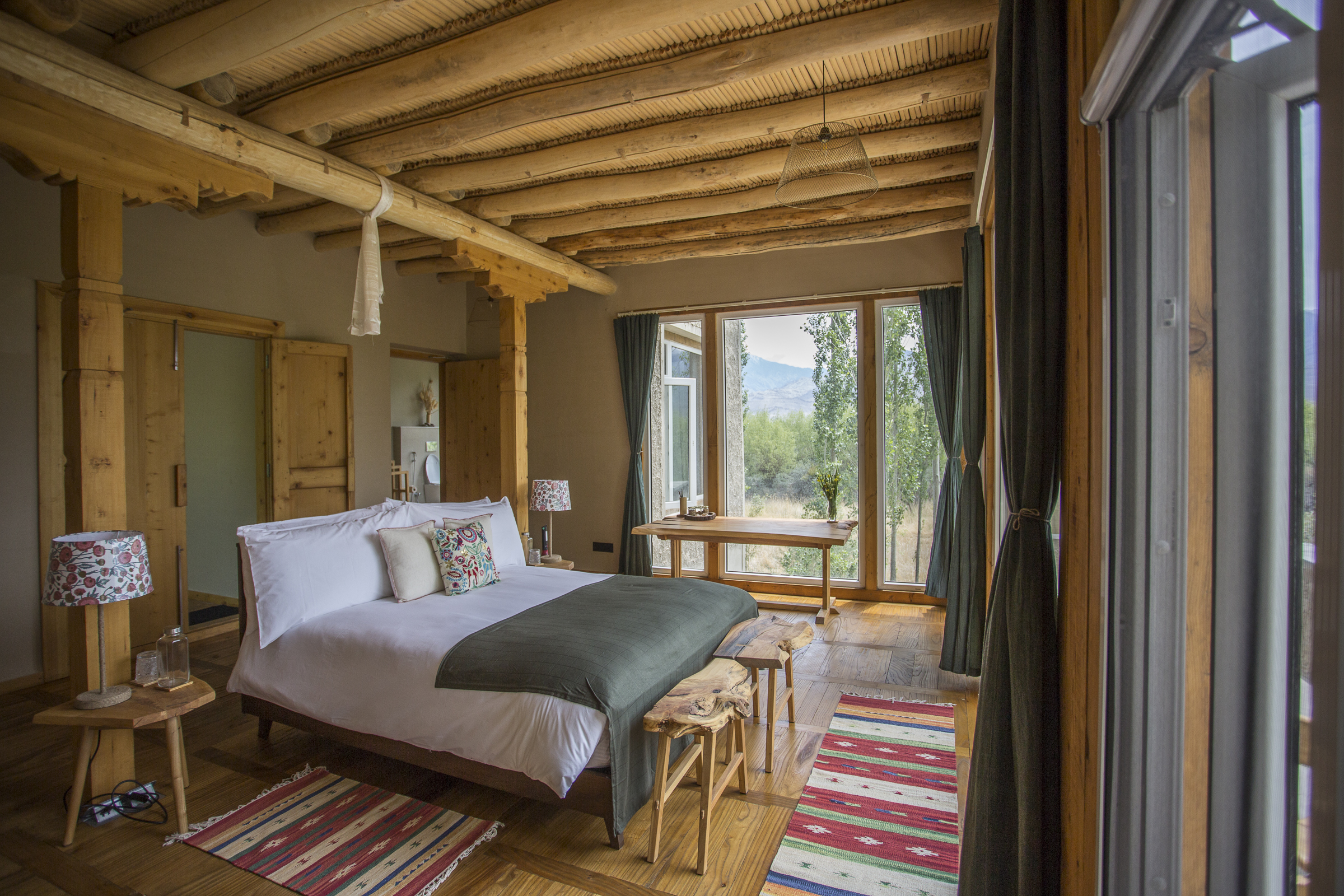 Bedroom framed by natural wood and mountain view