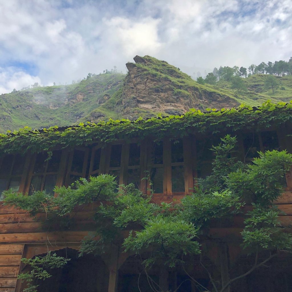 Vine-covered rooftops and clouds that drift between the peaks